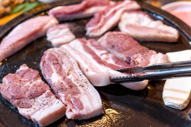 Kore restoranında tavada siyah domuz yemeği, marul ile demir tabakta taze lezzetli Kore yemekleri mutfağı, yakın çekim, kopya alanı, yaşam tarzı