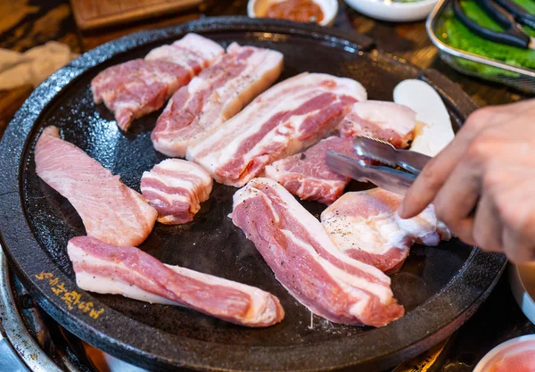 Stekt svart fläsk måltid i Korea restaurang, färska läckra koreanska maträtter på järn tallrik med sallad, närbild, kopiera utrymme, livsstil — Stockfoto
