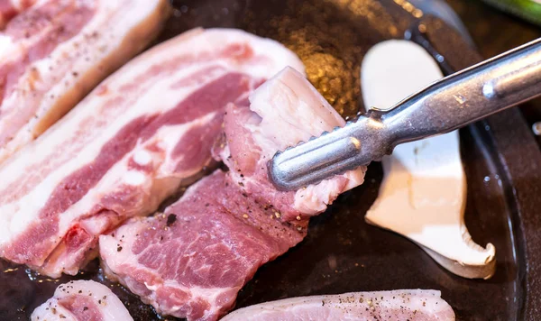 Kore restoranında tavada siyah domuz yemeği, marul ile demir tabakta taze lezzetli Kore yemekleri mutfağı, yakın çekim, kopya alanı, yaşam tarzı