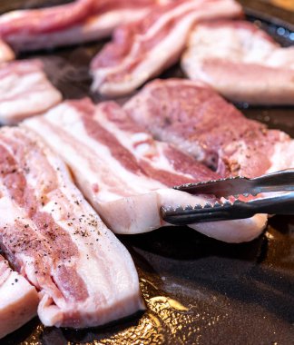 Kore restoranında tavada siyah domuz yemeği, marul ile demir tabakta taze lezzetli Kore yemekleri mutfağı, yakın çekim, kopya alanı, yaşam tarzı