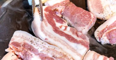 Kore restoranında tavada siyah domuz yemeği, marul ile demir tabakta taze lezzetli Kore yemekleri mutfağı, yakın çekim, kopya alanı, yaşam tarzı