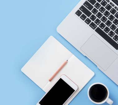 Kız açık beyaz kitap veya dizüstü bilgisayar ve aksesuarları ile minimal temiz açık mavi masa üzerinde muhasebe yazmak, kopya alanı, düz yatıyordu, üst görünüm, mock up