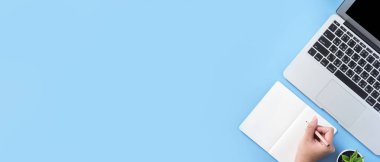 Kız açık beyaz kitap veya dizüstü bilgisayar ve aksesuarları ile minimal temiz açık mavi masa üzerinde muhasebe yazmak, kopya alanı, düz yatıyordu, üst görünüm, mock up