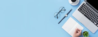 Kız açık beyaz kitap veya dizüstü bilgisayar ve aksesuarları ile minimal temiz açık mavi masa üzerinde muhasebe yazmak, kopya alanı, düz yatıyordu, üst görünüm, mock up