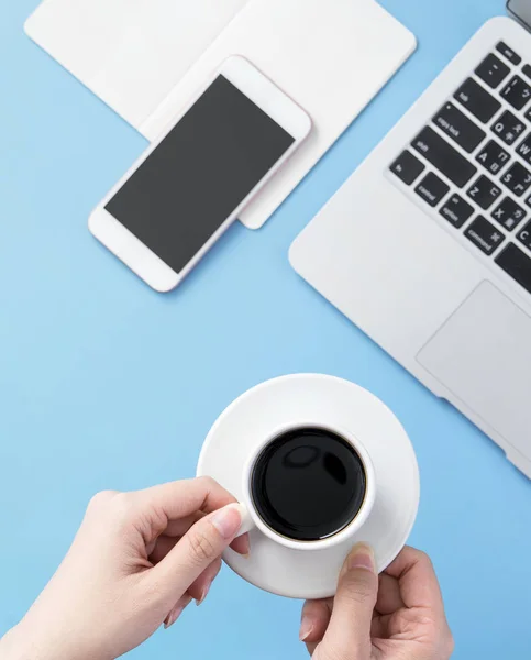 Freelancer blog writer woman drinking for relax on a clean light blue desk with coffee, work at home concept, copy space, flat lay, top view, mock up