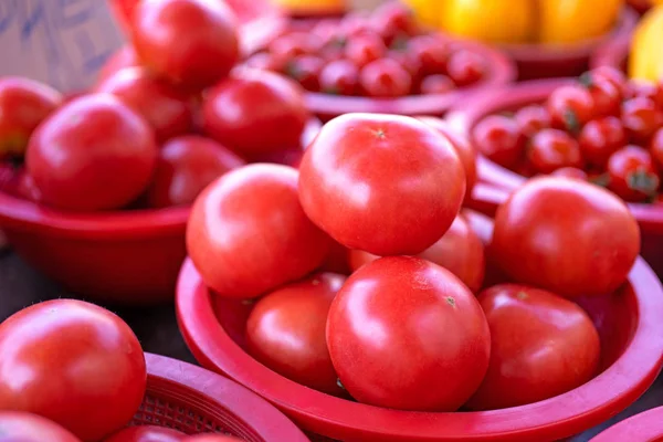 Delicious fresh tomatoes fruit vegetable food in red plastic basket at tradition market afternoon, Seoul, South Korea, harvest concept, close up. — Stock Photo, Image