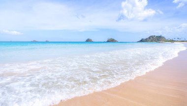 Güneşli mavi gökyüzü ile izole edilmiş yumuşak dalgaları olan harika, altın renkli kumlu plaj. Tropikal sakin turizm fikri, kopyala alanı, kapat