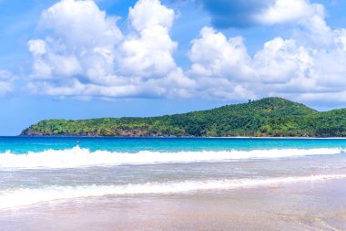 Güneşli mavi gökyüzü ile izole edilmiş yumuşak dalgaları olan harika, altın renkli kumlu plaj. Tropikal sakin turizm fikri, kopyala alanı, kapat