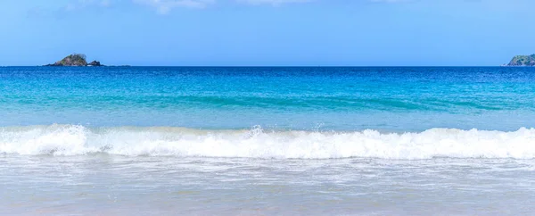 Linda praia de areia de cor dourada incrível com ondas suaves isoladas com céu azul ensolarado. Conceito de ideia turística calma tropical, espaço de cópia, close-up — Fotografia de Stock