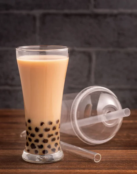 Délicieux thé au lait à bulles avec de la paille dans du verre à boire sur fond de table en bois, concept de réduire le plastique pour aller à Taiwan, gros plan, espace de copie — Photo