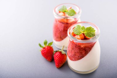 Havadar mavi arka plan, kopya alanı, yakın izole nane ve doğranmış sarkokus tepesi ile delikoz ve besleyici çift renkli (renkli) çilek tatlılar