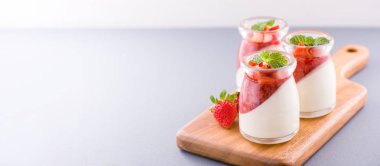 Havadar mavi arka plan, kopya alanı, yakın izole nane ve doğranmış sarkokus tepesi ile delikoz ve besleyici çift renkli (renkli) çilek tatlılar