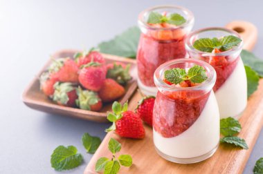 Havadar mavi arka plan, kopya alanı, yakın izole nane ve doğranmış sarkokus tepesi ile delikoz ve besleyici çift renkli (renkli) çilek tatlılar