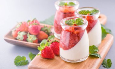 Havadar mavi arka plan, kopya alanı, yakın izole nane ve doğranmış sarkokus tepesi ile delikoz ve besleyici çift renkli (renkli) çilek tatlılar