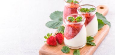 Havadar mavi arka plan, kopya alanı, yakın izole nane ve doğranmış sarkokus tepesi ile delikoz ve besleyici çift renkli (renkli) çilek tatlılar