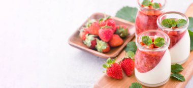 Havadar mavi arka plan, kopya alanı, yakın izole nane ve doğranmış sarkokus tepesi ile delikoz ve besleyici çift renkli (renkli) çilek tatlılar