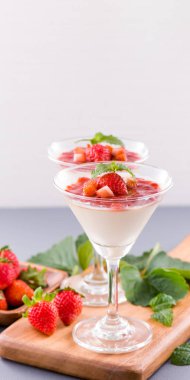 Havadar mavi arka plan, kopya alanı, yakın izole nane ve doğranmış sarkokus tepesi ile delikoz ve besleyici çift renkli (renkli) çilek tatlılar