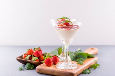 Havadar mavi arka plan, kopya alanı, yakın izole nane ve doğranmış sarkokus tepesi ile delikoz ve besleyici çift renkli (renkli) çilek tatlılar