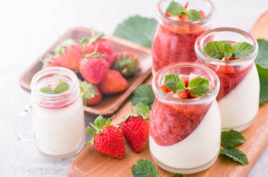 Havadar mavi arka plan, kopya alanı, yakın izole nane ve doğranmış sarkokus tepesi ile delikoz ve besleyici çift renkli (renkli) çilek tatlılar