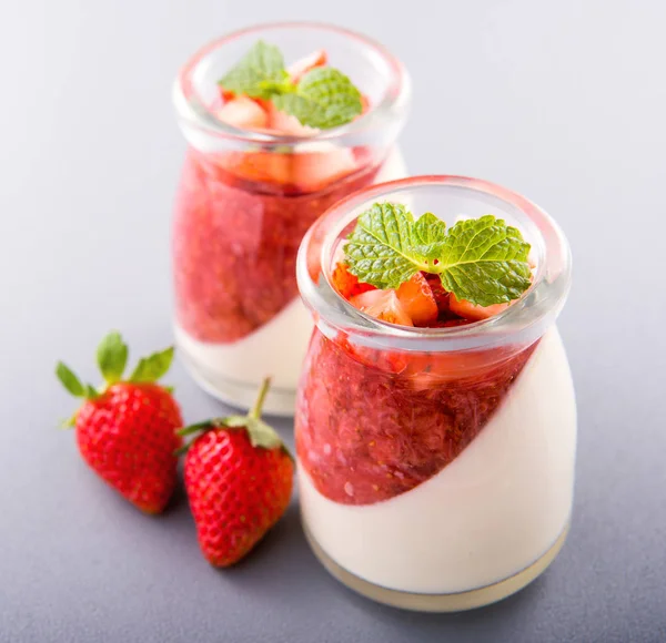 Havadar mavi arka plan, kopya alanı, yakın izole nane ve doğranmış sarkokus tepesi ile delikoz ve besleyici çift renkli (renkli) çilek tatlılar