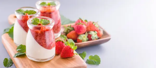 Delicous and nutritious double color (colour) strawberry desserts with mint and diced sarcocarp topping isolated with airy blue background, copy space, close up — Stock Photo, Image