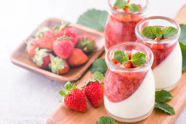 Havadar mavi arka plan, kopya alanı, yakın izole nane ve doğranmış sarkokus tepesi ile delikoz ve besleyici çift renkli (renkli) çilek tatlılar