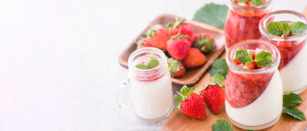 Delicate en voedzame dubbele kleur (kleur) aardbei desserts met mint en in blokjes gesneden sarcocarp topping geïsoleerd met luchtige blauwe achtergrond, kopieer ruimte, close-up — Stockfoto