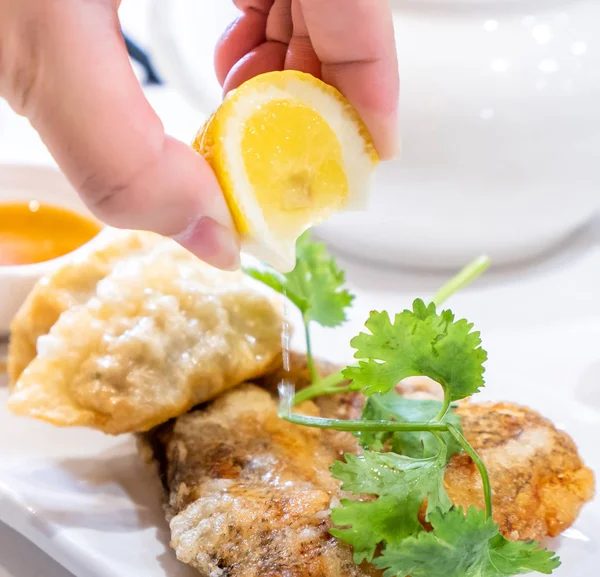 Delicious dim sum, famous cantonese food in asia - Fried fish and dumplings with lemon, sauce and tea in hong kong yumcha restaurant, close up