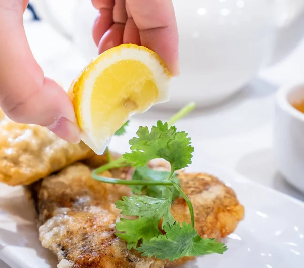 Delicious dim sum, famous cantonese food in asia - Fried fish and dumplings with lemon, sauce and tea in hong kong yumcha restaurant, close up