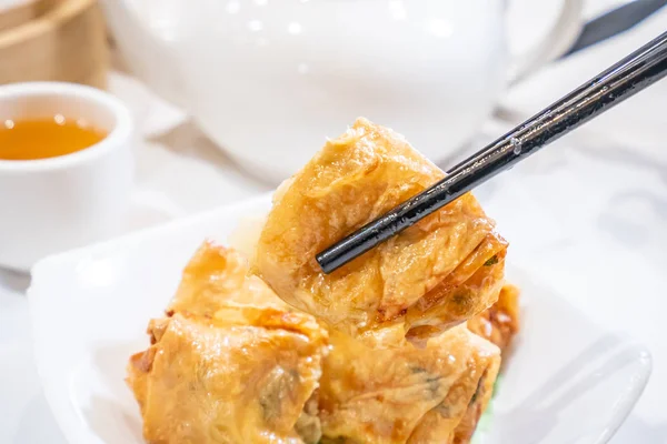 Delicious dim sum, famous cantonese food in asia - Fried bean curd (tofu skin) rolls with shrimp and prawn in hong kong yumcha restaurant, close up