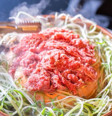 Seul Kore restoranda sığır Barbekü Bulgogi, dilimlenmiş yeşil soğan ile bakır Pan üzerinde yaşam tarzı taze Kore Gıda mutfağı, yakın yukarı, kopya alanı