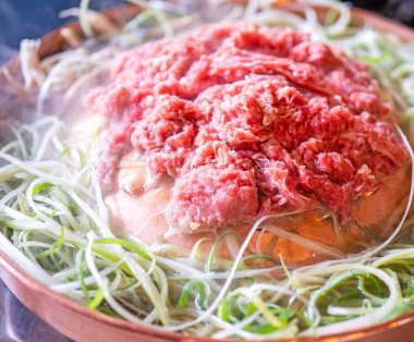 Seul Kore restoranda sığır Barbekü Bulgogi, dilimlenmiş yeşil soğan ile bakır Pan üzerinde yaşam tarzı taze Kore Gıda mutfağı, yakın yukarı, kopya alanı