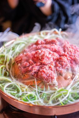 Seul Kore restoranda sığır Barbekü Bulgogi, dilimlenmiş yeşil soğan ile bakır Pan üzerinde yaşam tarzı taze Kore Gıda mutfağı, yakın yukarı, kopya alanı