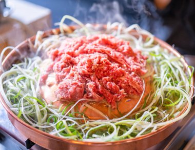 Seul Kore restoranda sığır Barbekü Bulgogi, dilimlenmiş yeşil soğan ile bakır Pan üzerinde yaşam tarzı taze Kore Gıda mutfağı, yakın yukarı, kopya alanı