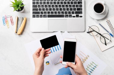 Online fatura ödeme kavramı, bir kadın ofis masasında sahte kredi kartı ve cep telefonu kullanarak güzel moda mermer arka plan üzerinde izole, kopya alanı, Topview, flatlay, çekim