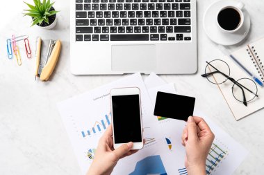 Online fatura ödeme kavramı, bir kadın ofis masasında sahte kredi kartı ve cep telefonu kullanarak güzel moda mermer arka plan üzerinde izole, kopya alanı, Topview, flatlay, çekim