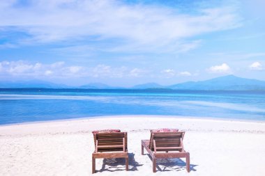 Mavi gökyüzü ile okyanusun yakınında muhteşem güzel kumlu plaj sandalyeler. Bir turizm fikri için yaz eğlence sakin tatil kavramı. Boş kopya alanı, tropikal peyzaj ilham