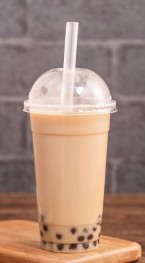 Tek kullanımlık eşya kavramı popüler Tayvan içki kabarcık süt çayı ile ahşap masa arka plan plastik fincan ve saman ile Takeout, yakın, kopya alanı
