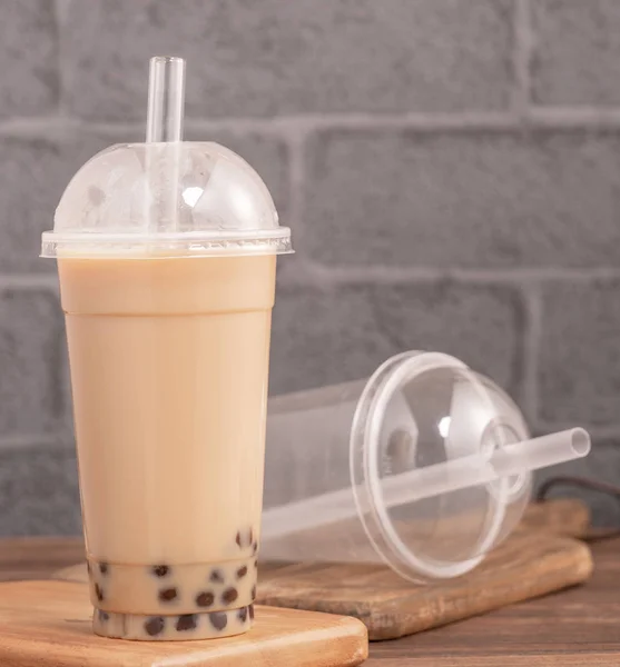 À emporter avec article jetable concept populaire Taiwan boisson bulle thé au lait avec tasse en plastique et de la paille sur fond de table en bois, fermer, copier l'espace — Photo