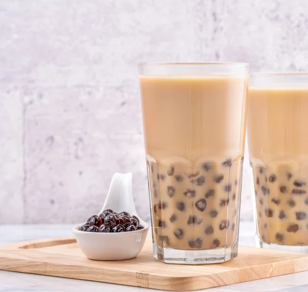 Boisson populaire à Taiwan - thé au lait à bulles avec boule de perles de tapioca en verre à boire sur fond de plateau en bois de table blanc en marbre, gros plan, espace de copie — Photo