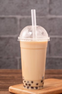 Tek kullanımlık eşya kavramı popüler Tayvan içki kabarcık süt çayı ile ahşap masa arka plan plastik fincan ve saman ile Takeout, yakın, kopya alanı
