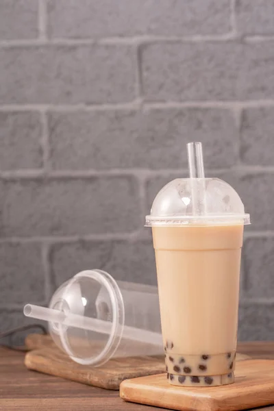 Take-out mit Einweg-Artikel-Konzept beliebten Taiwan trinken Bubble Milch Tea mit Plastikbecher und Stroh auf Holztischhintergrund, Nahaufnahme, Kopierraum — Stockfoto