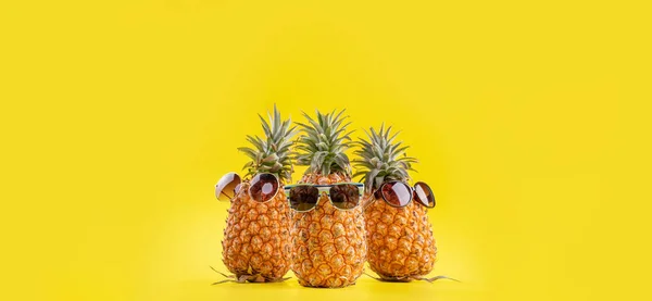 Kreativ ananas tittar upp med solglasögon och skal isolerade på gul bakgrund, sommarsemester strand idé designmönster, kopiera utrymme närbild — Stockfoto