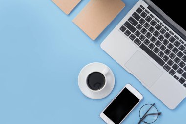 İş konsepti. Temiz parlak ışık mavi ofis masa masası, dizüstü kahve ve akıllı telefon ile minimal tarzı, kopya alanı, üst görünüm, düz yatıyordu, mockup