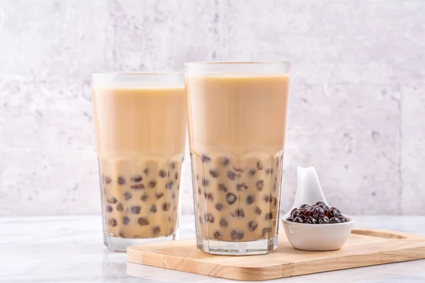 Boisson populaire à Taiwan - thé au lait à bulles avec boule de perles de tapioca en verre à boire sur fond de plateau en bois de table blanc en marbre, gros plan, espace de copie — Photo