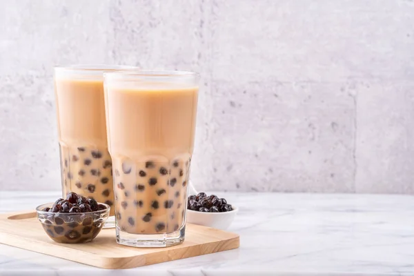 Boisson populaire à Taiwan - thé au lait à bulles avec boule de perles de tapioca en verre à boire sur fond de plateau en bois de table blanc en marbre, gros plan, espace de copie — Photo