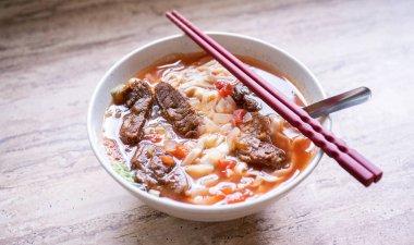 Parlak ahşap masada kase domates sosu suyu ile Sığır şehriye ramen yemek, Tayvan ünlü Çin tarzı gıda, yakın, üst görünümü, kopya alanı