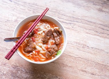 Parlak ahşap masada kase domates sosu suyu ile Sığır şehriye ramen yemek, Tayvan ünlü Çin tarzı gıda, yakın, üst görünümü, kopya alanı