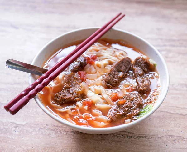 明るい木製のテーブルの上にボウルにトマトソーススープと牛肉ラーメンの食事, 台湾の有名な中華料理, クローズアップ, トップビュー, コピースペース — ストック写真