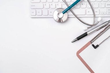 Beyaz masa arka planı üzerinde klavye üzerinde Stetoskop. Online tıbbi bilgi tedavi teknolojisi ofis konsepti, üst görünüm, düz yatıyordu, kopyalama alanı